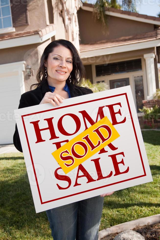 Woman Holding Sold Real Estate Sign In Front of House photo