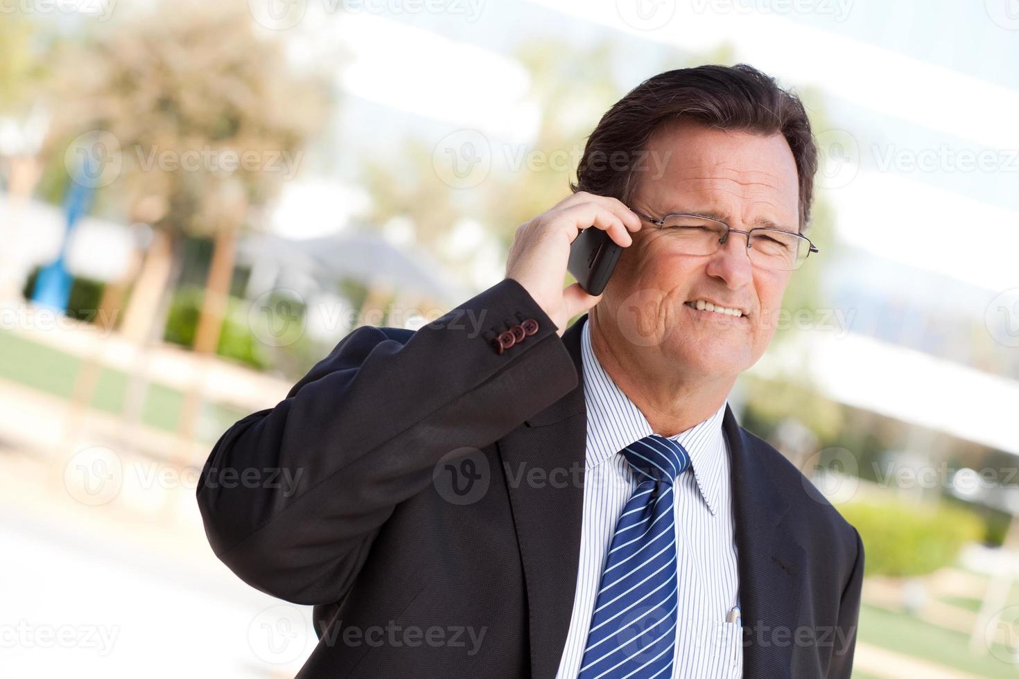 Businessman Smiles as He Talks on His Cell Phone photo