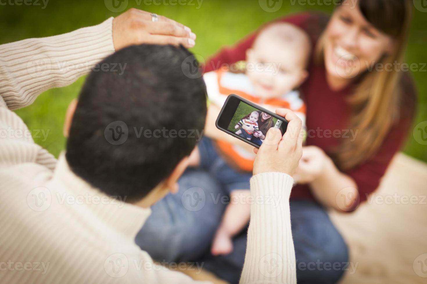 Happy Mixed Race Parents and Baby Boy Taking Self Portraits photo