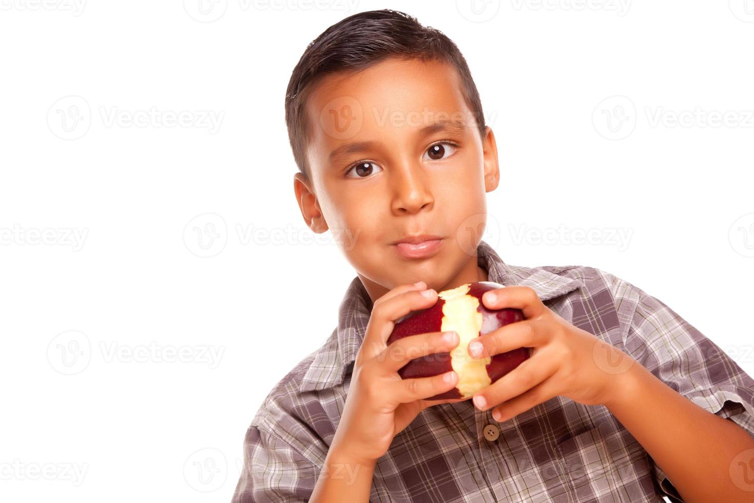 adorable niño hispano comiendo una gran manzana roja foto