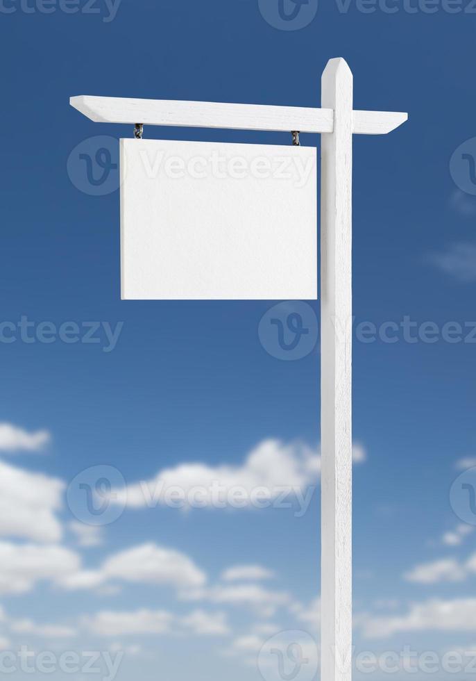 Blank Real Estate Sign Over A Blue Sky with Clouds. photo