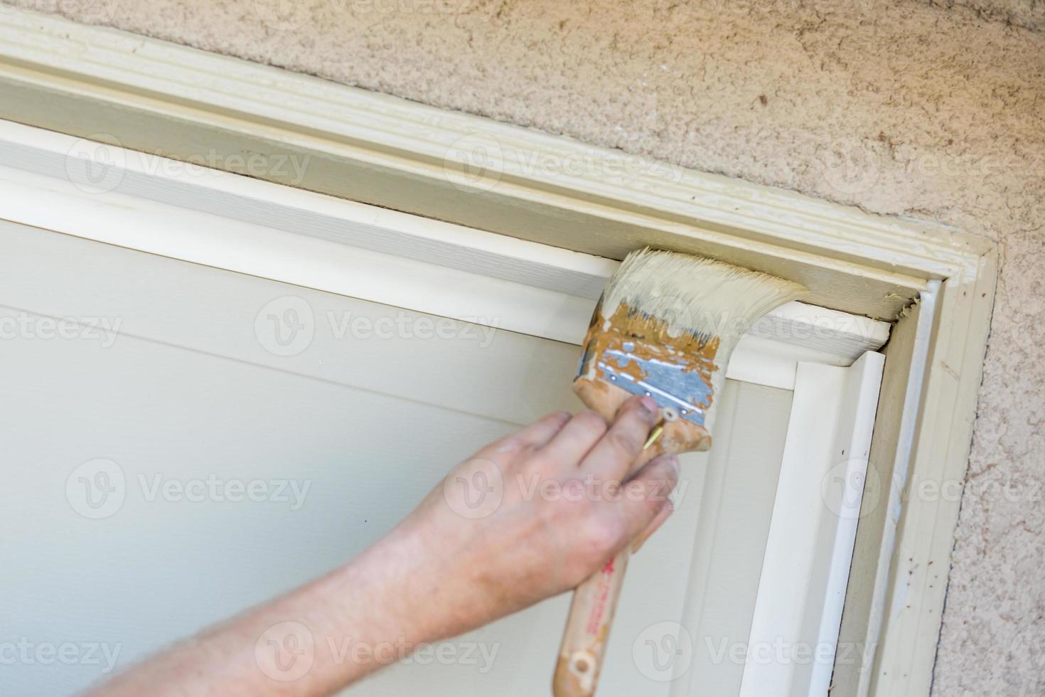 Professional Painter Cutting In With Brush to Paint Garage Door Frame