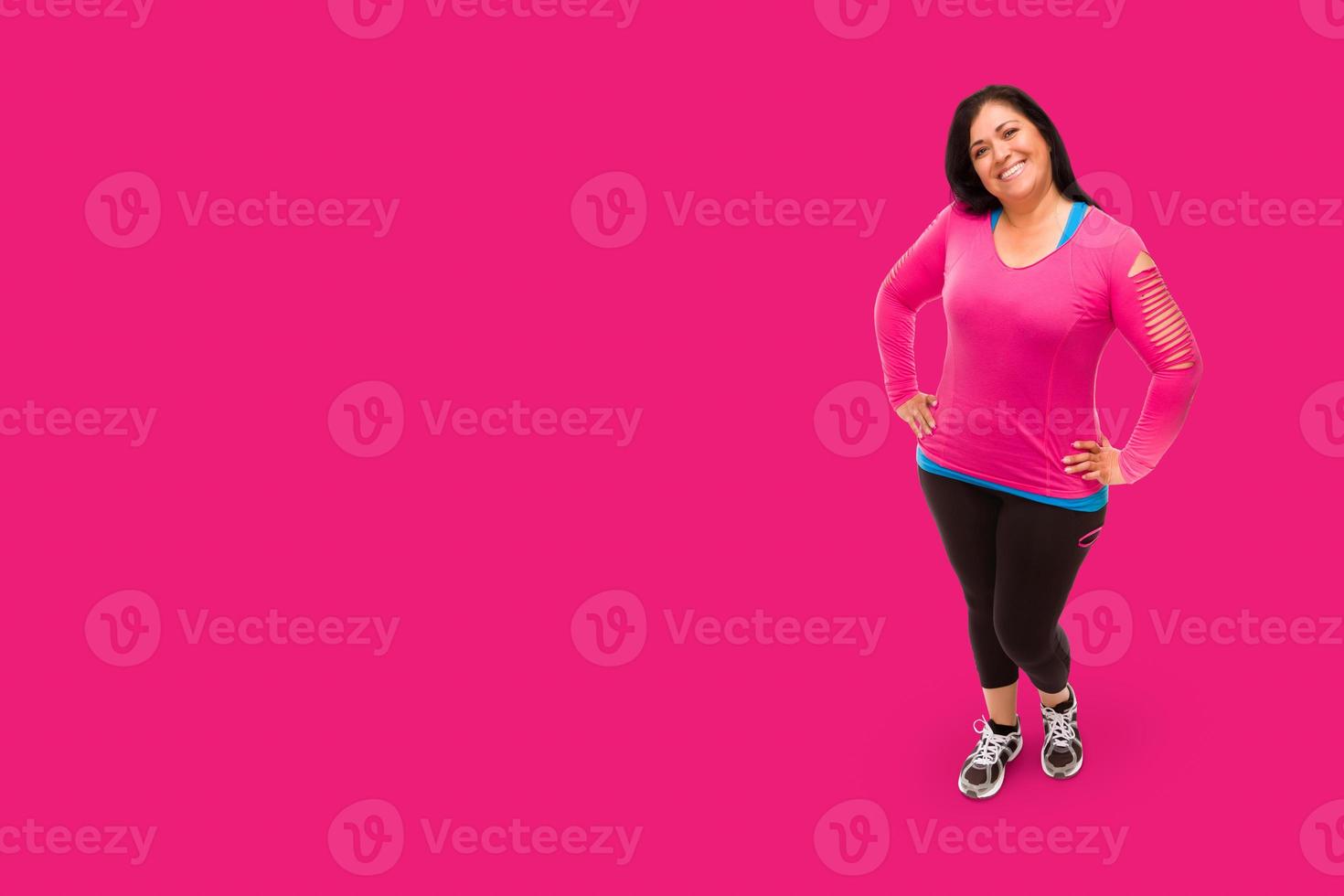 Middle Aged Hispanic Woman In Workout Clothes Against A Bright Pink Background. photo