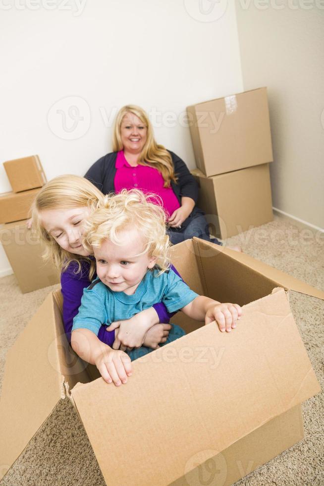Young Family In Empty Room Playing With Moving Boxes photo