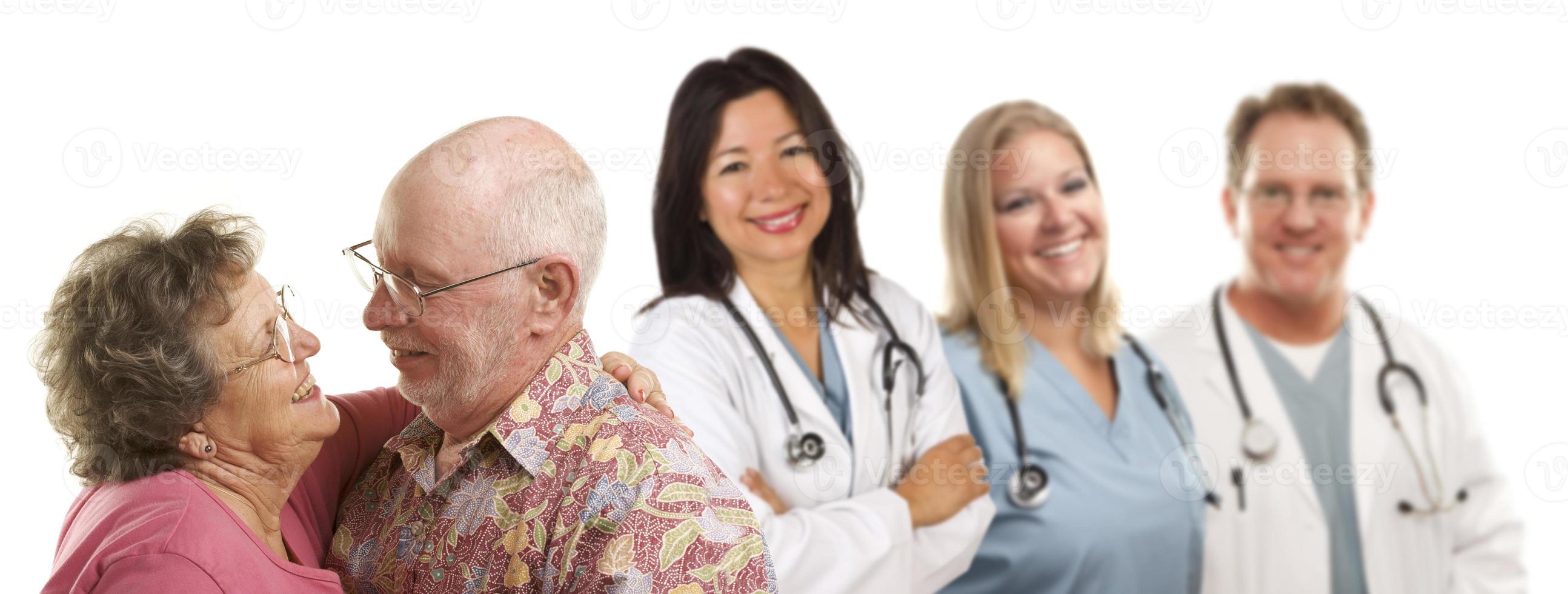pareja mayor con médicos o enfermeras detrás foto