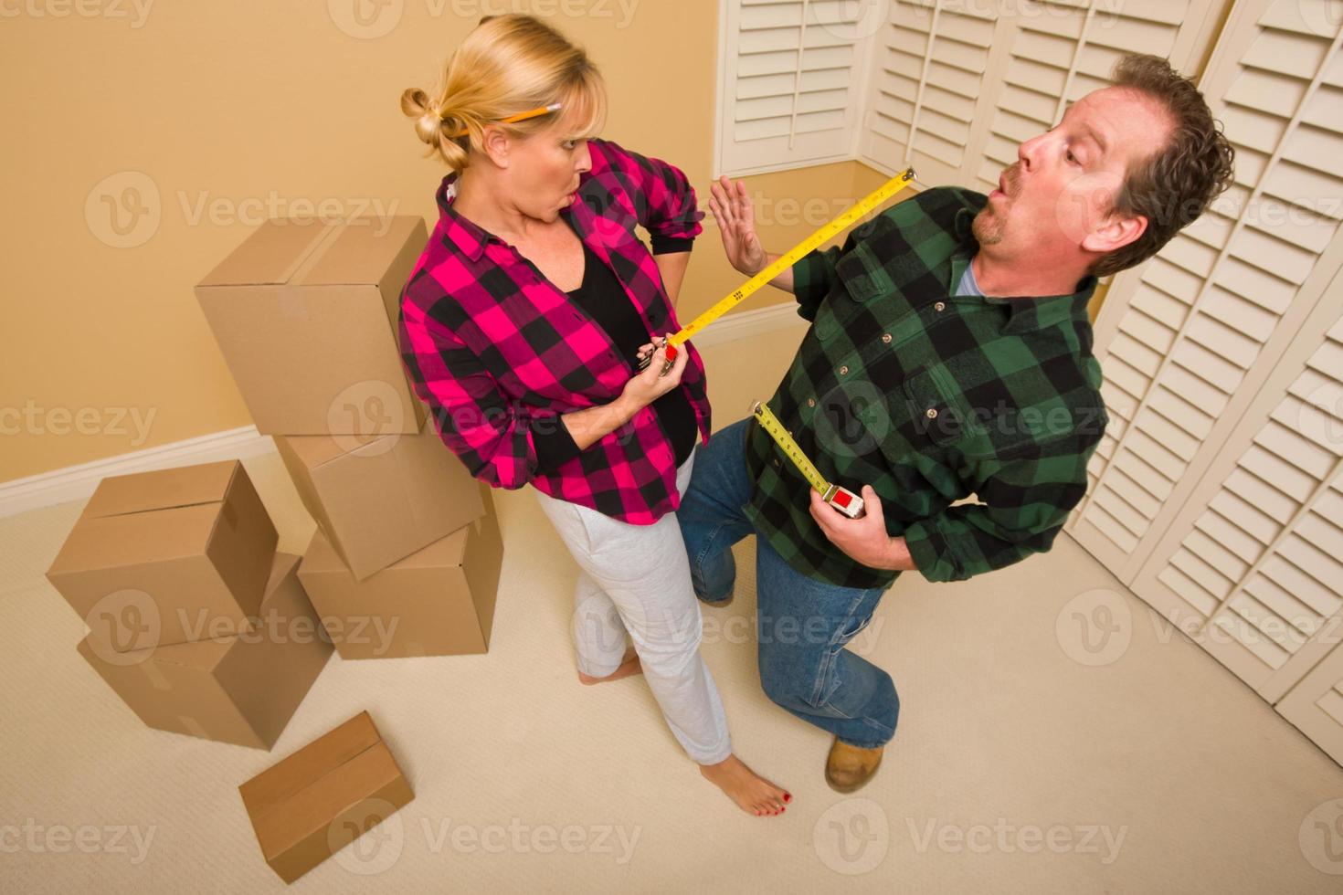 Couple Having Fun Sword Fight with Tape Measures photo