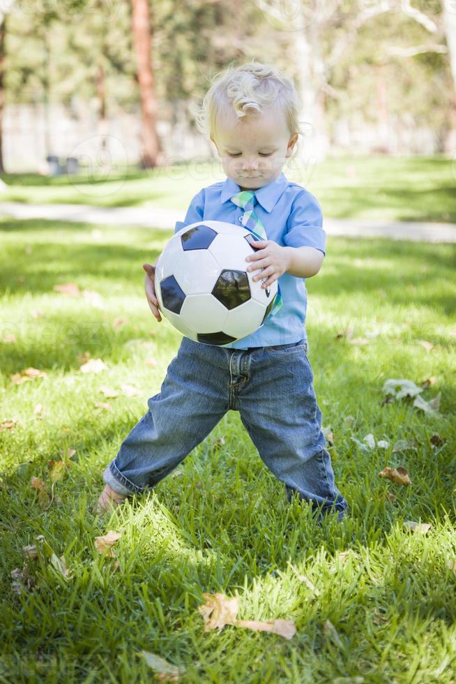 Young Cute Boy Playing with Soccer Ball in Park photo