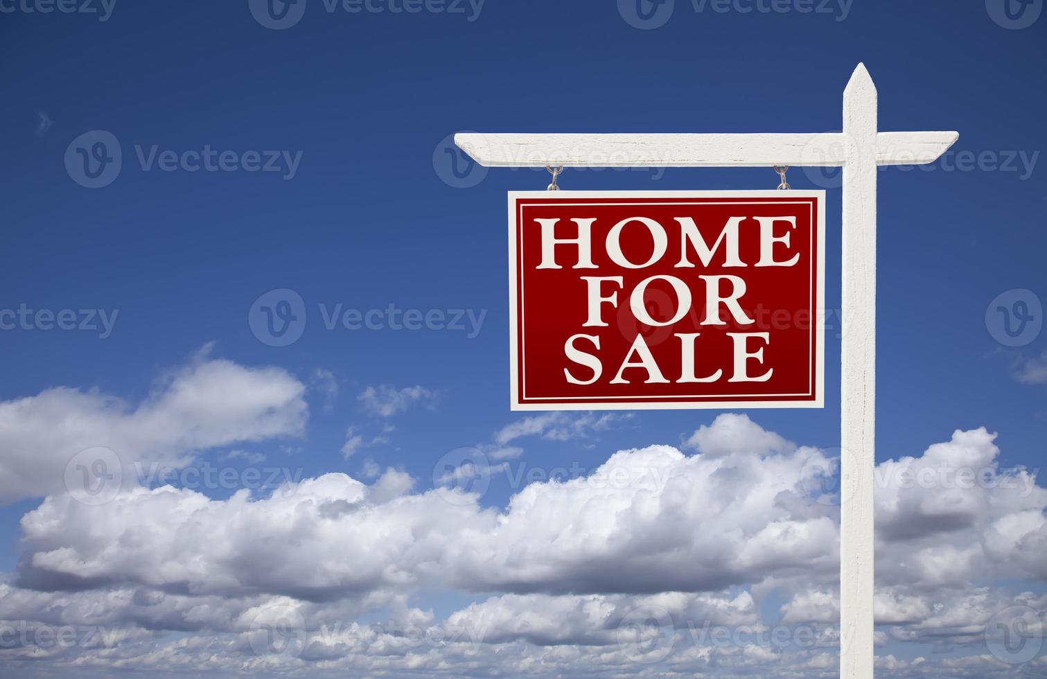 casa roja en venta signo de bienes raíces sobre nubes y cielo foto