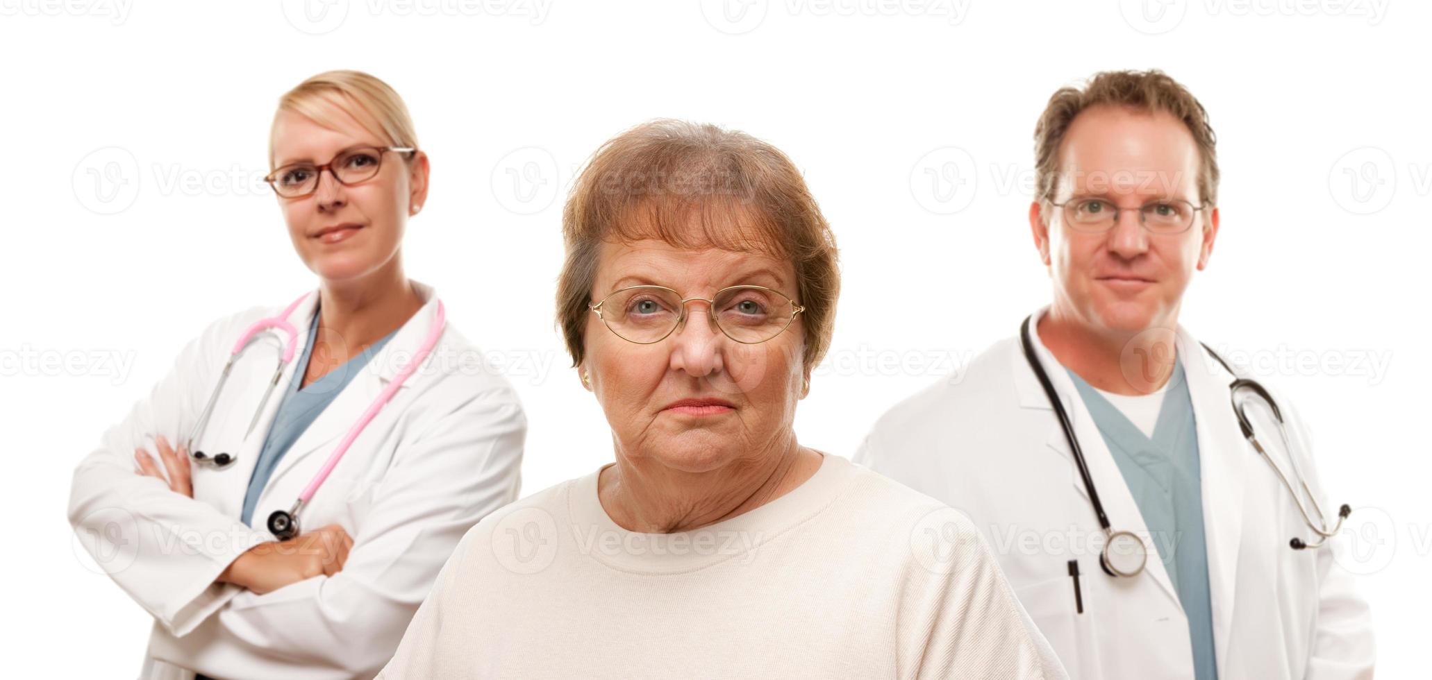 Concerned Senior Woman with Doctors Behind photo