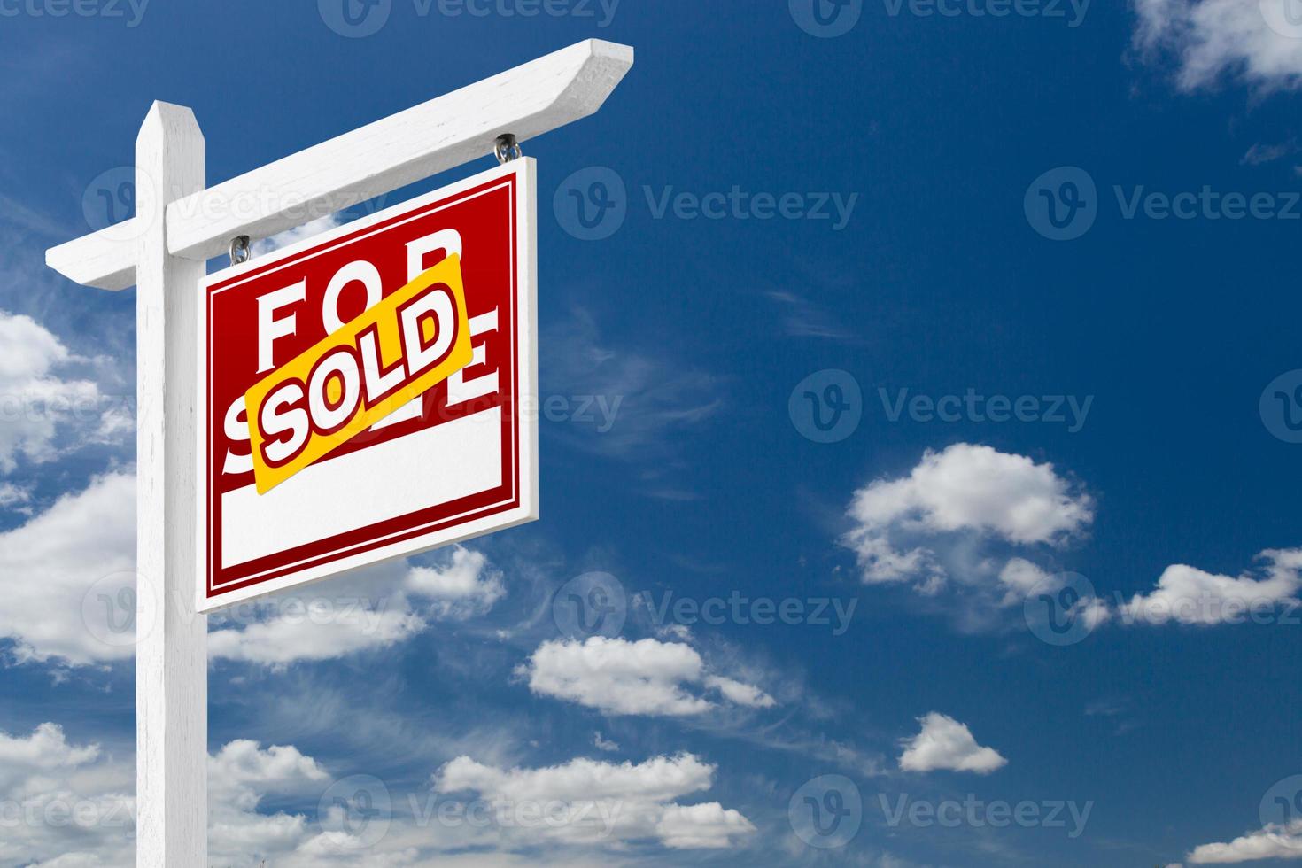 Right Facing Sold For Sale Real Estate Sign Over Blue Sky and Clouds With Room For Your Text. photo