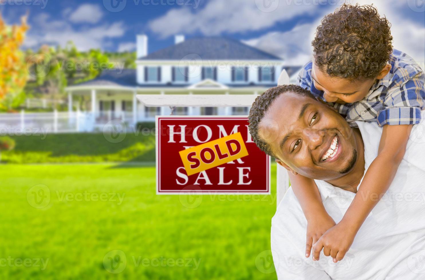 Father and Son In Front of Sold Sign and House photo