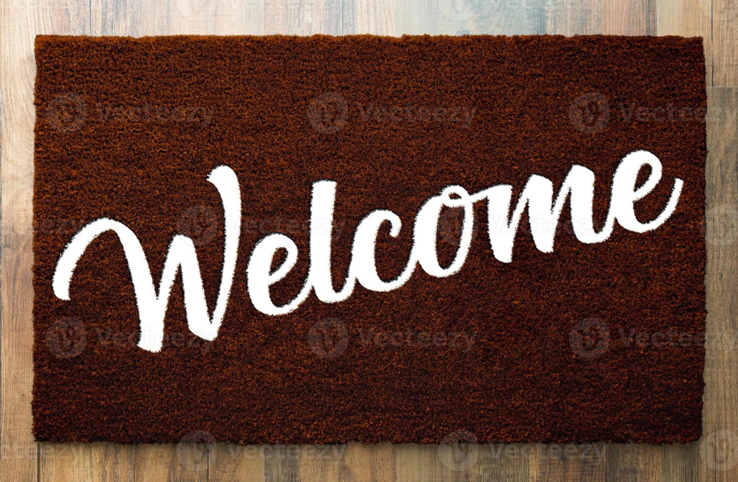 Dark Brown Welcome Mat On Wood Floor Background. photo