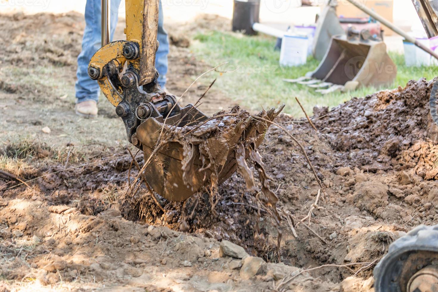 Working Excavator Tractor Digging A Trench At Construction Site photo