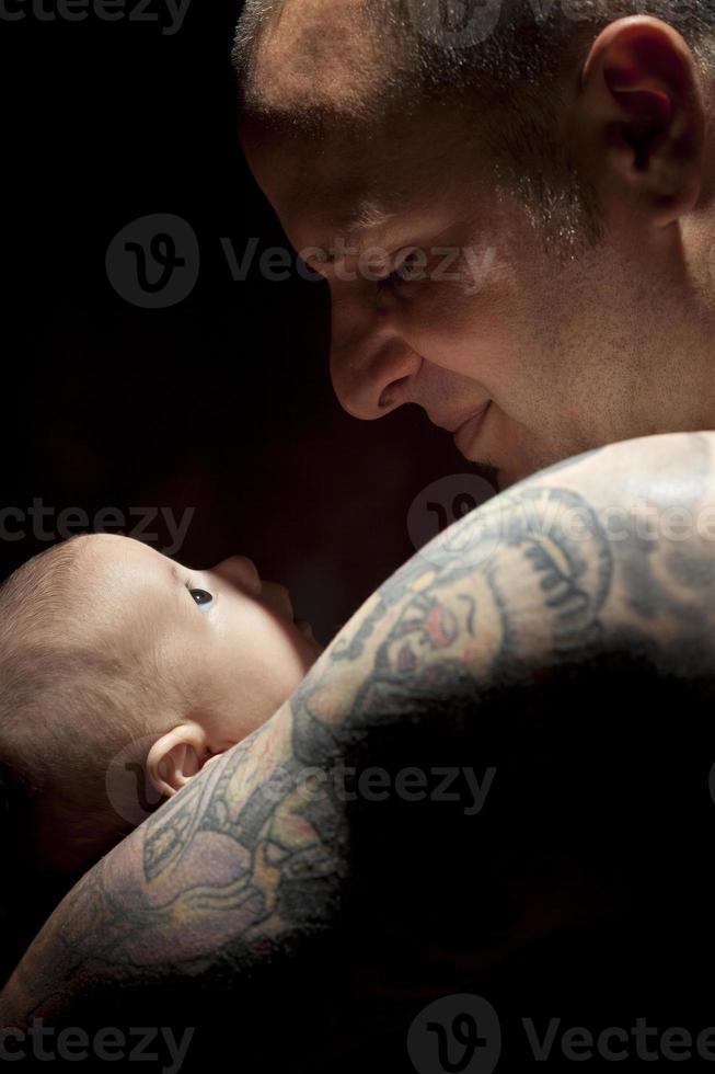 Young Father Holding His Mixed Race Newborn Baby photo