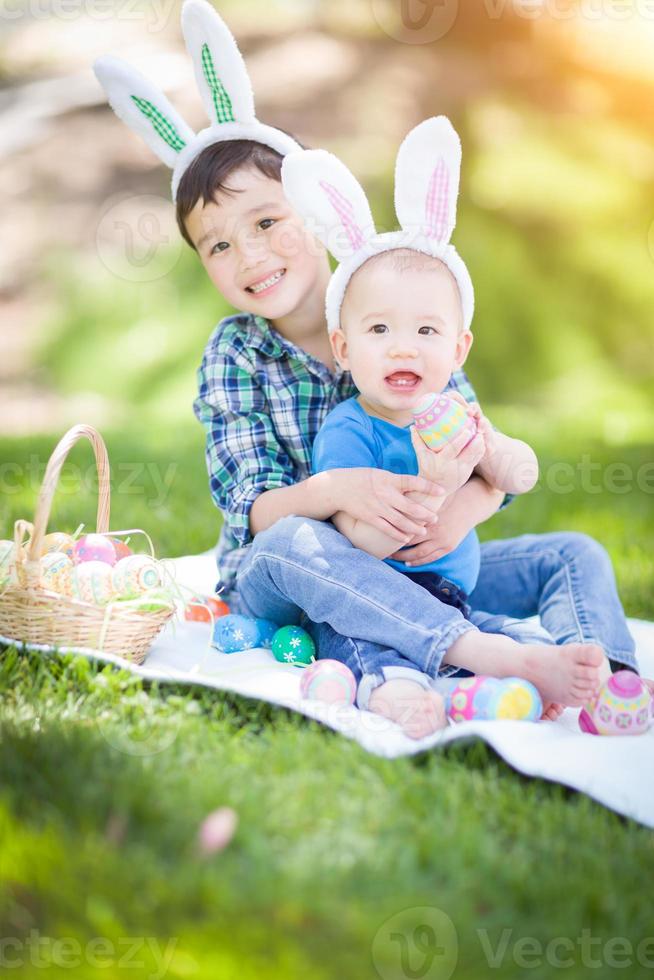 Mixed Race Chinese and Caucasian Boys Outside in Park Playing with Easter Eggs photo