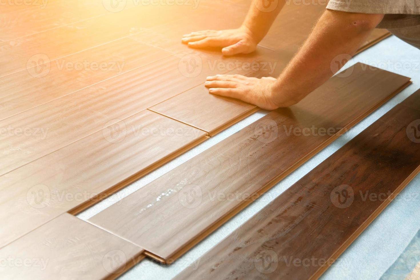 Man Installing New Laminate Wood Flooring photo