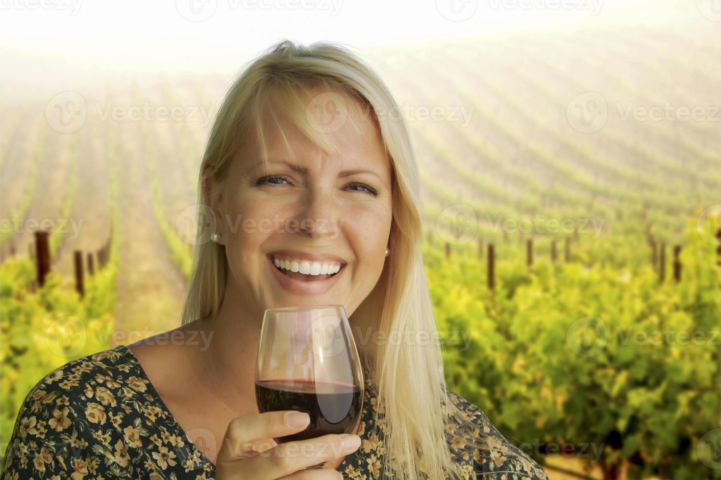 mujer atractiva disfrutando de una copa de vino en el viñedo foto