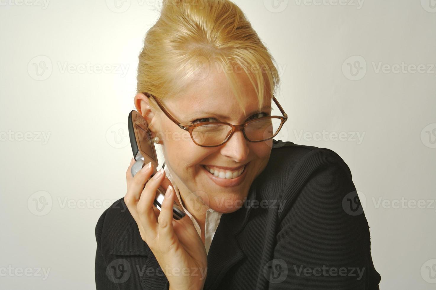 Elated Businesswoman Smiles While Using Her Cell Phone photo