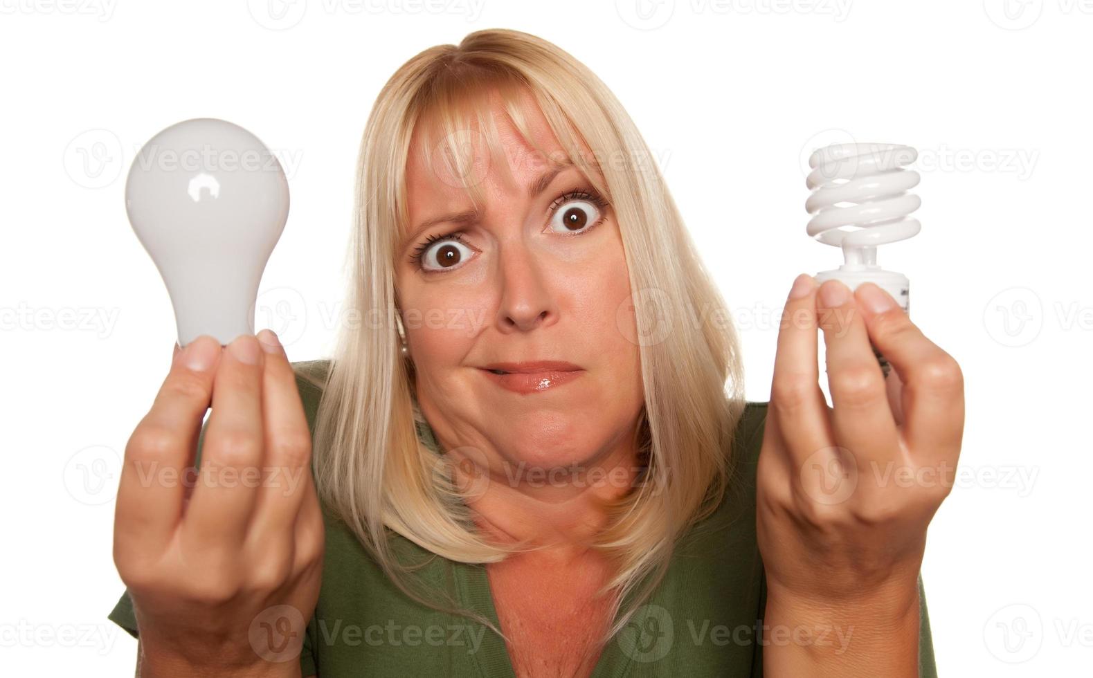Funny Woman Holding Energy Saving and Regular Light Bulbs photo