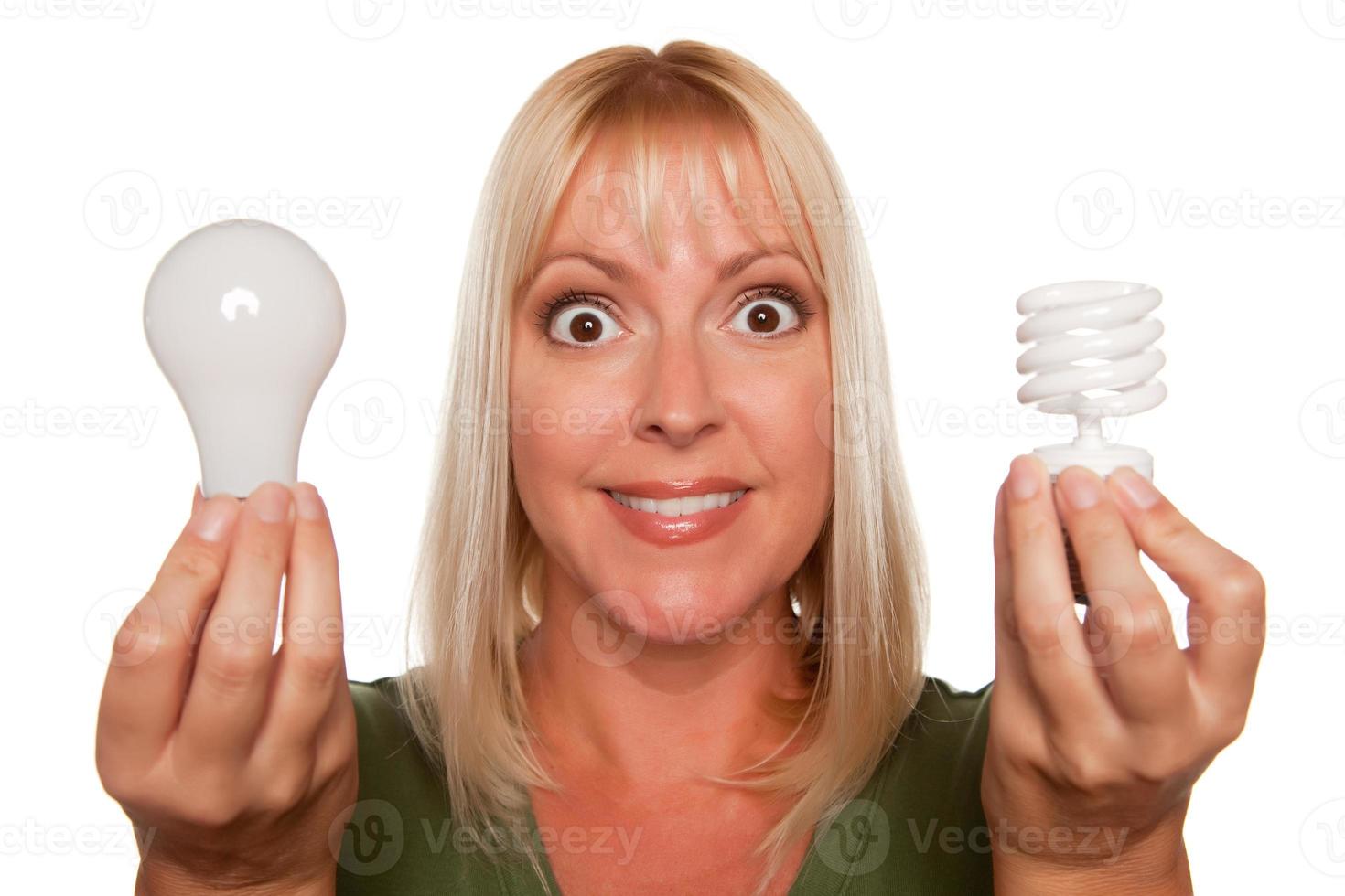 Woman Holds Energy Saving and Regular Light Bulbs photo
