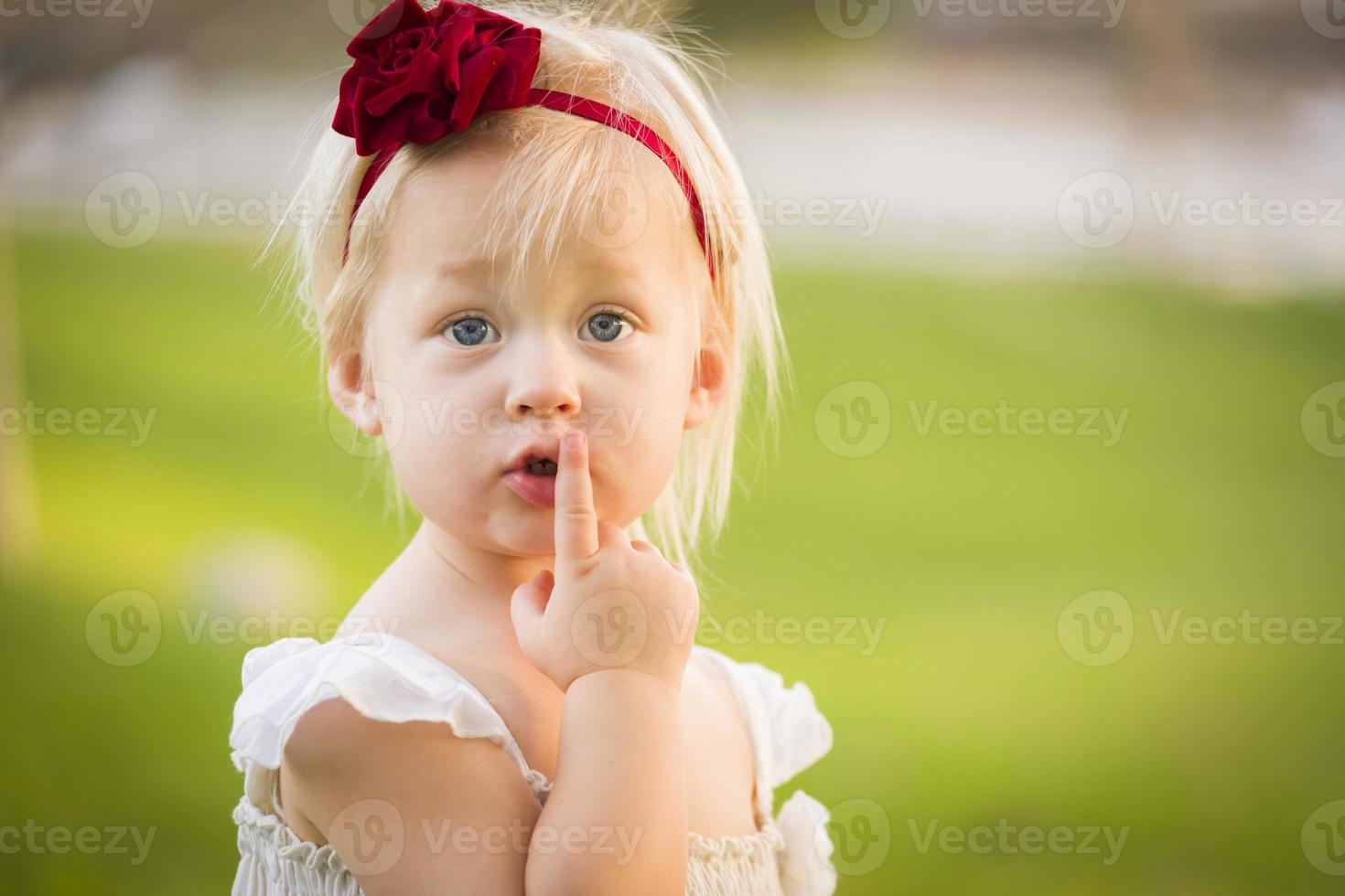 Adorable Little Girl Wearing White Dress In A Grass Field photo
