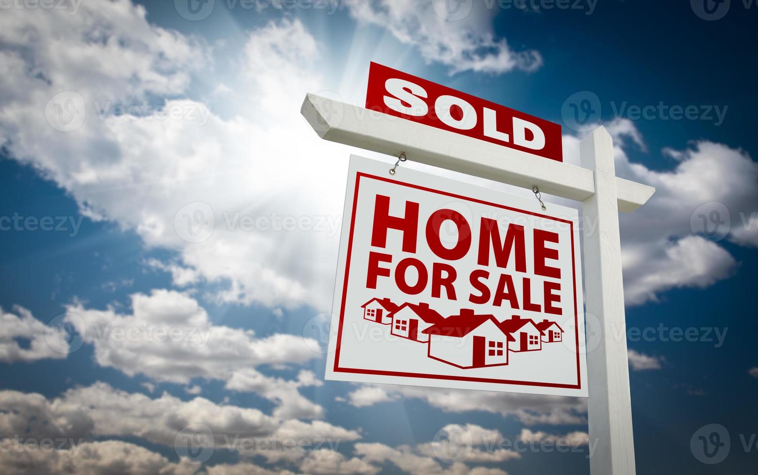 White and Red Sold Home for Sale Real Estate Sign Over Clouds and Sky photo