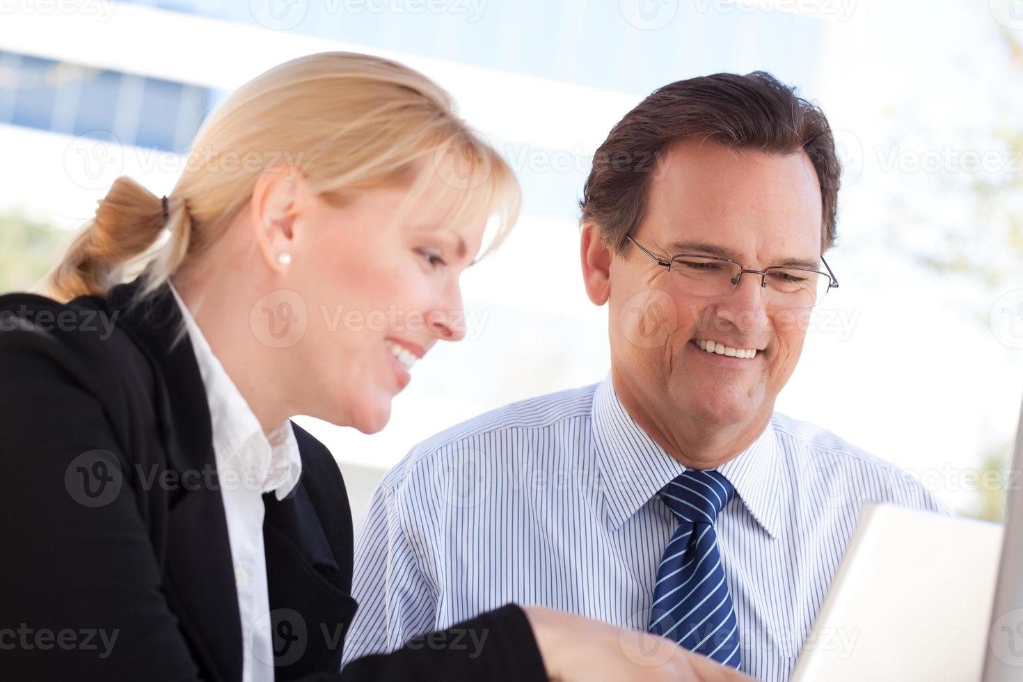 Businessman and Female Colleague Using Loptop Outdoors photo