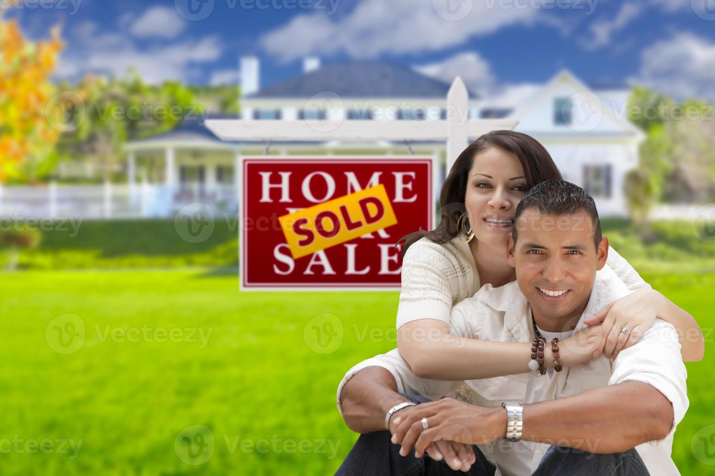 Hispanic Couple, New Home and Sold Real Estate Sign photo