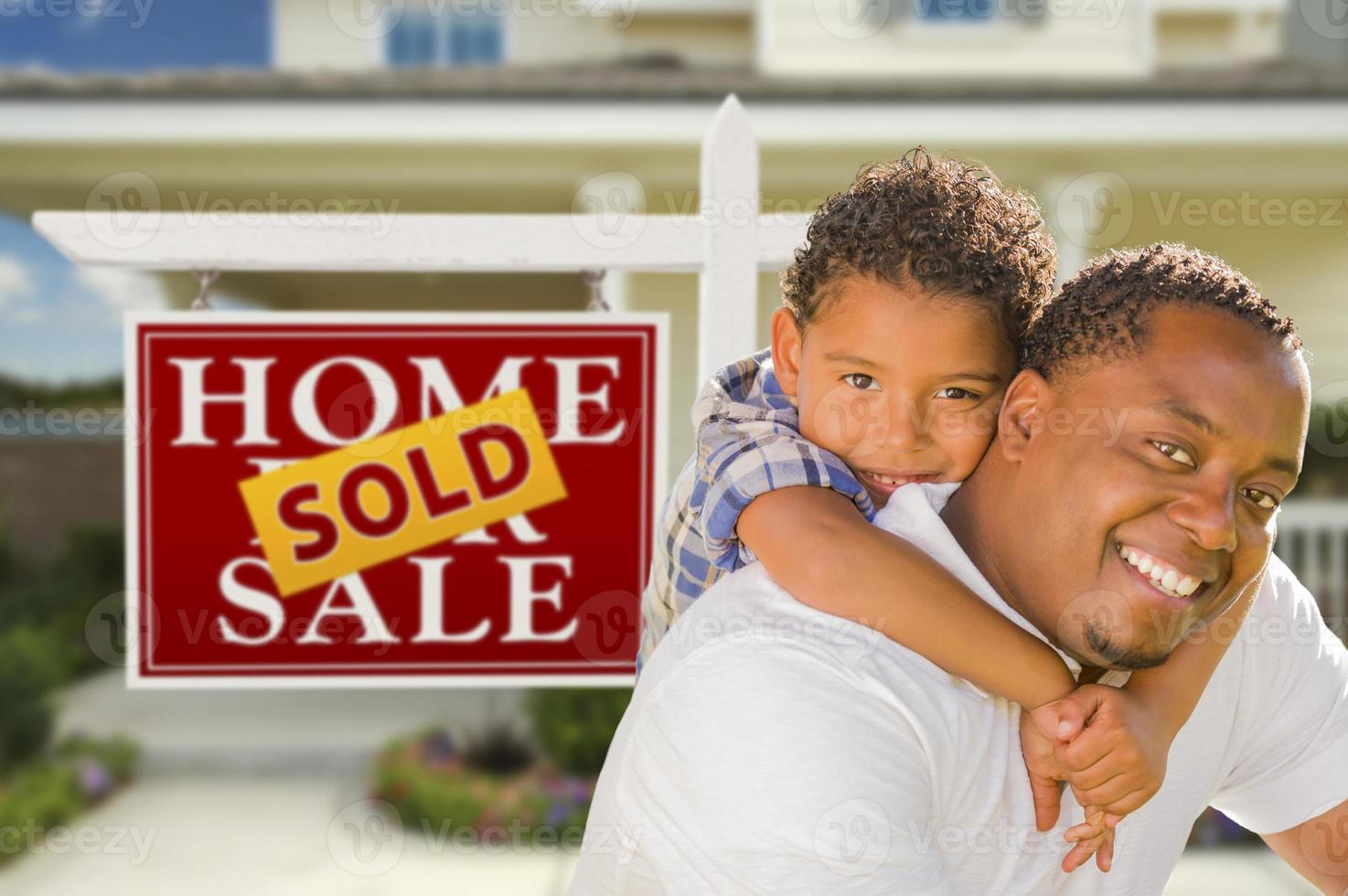 Mixed Race Father and Son In Front of Real Estate Sign and House photo