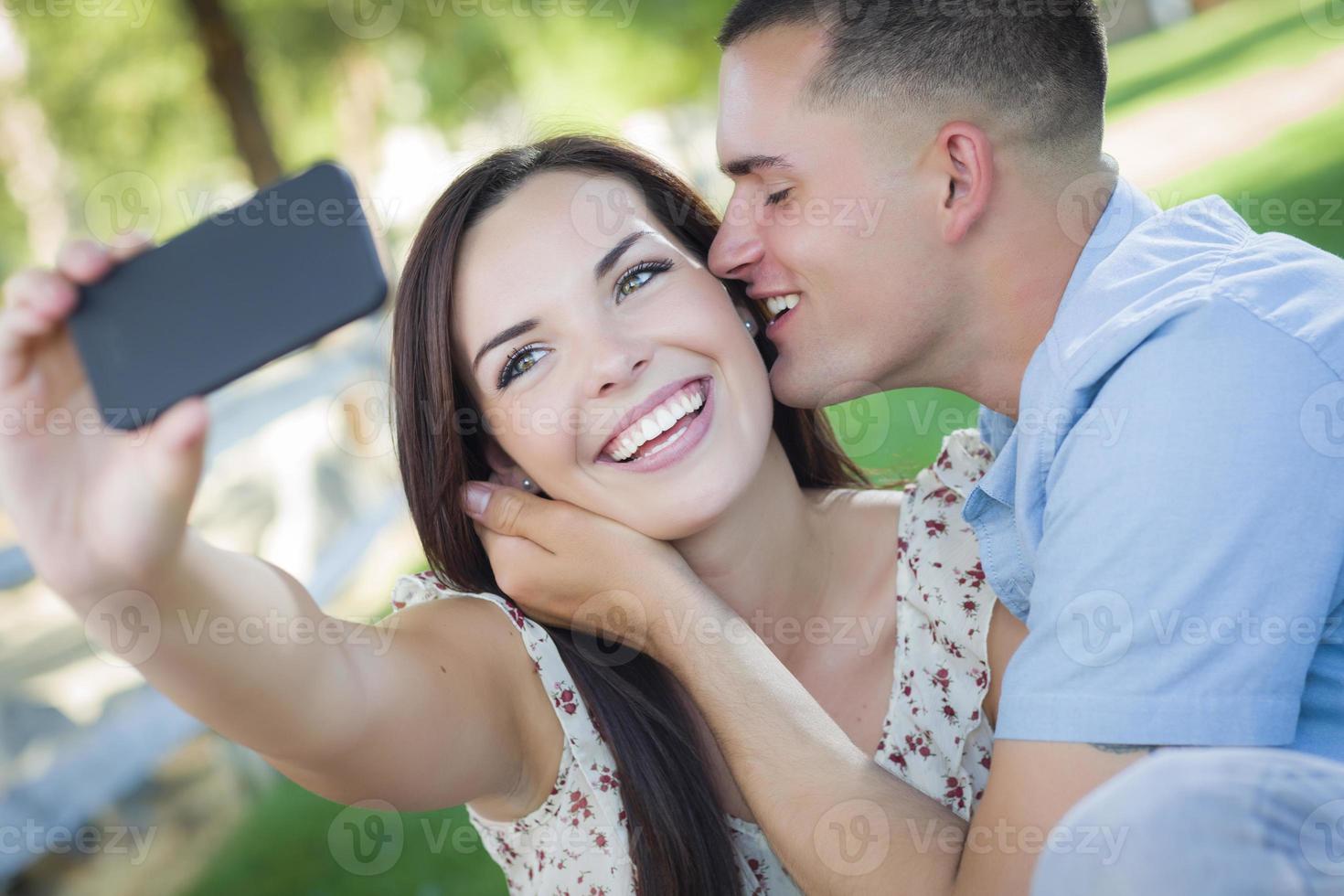 Mixed Race Couple Taking Self Portrait in Park photo