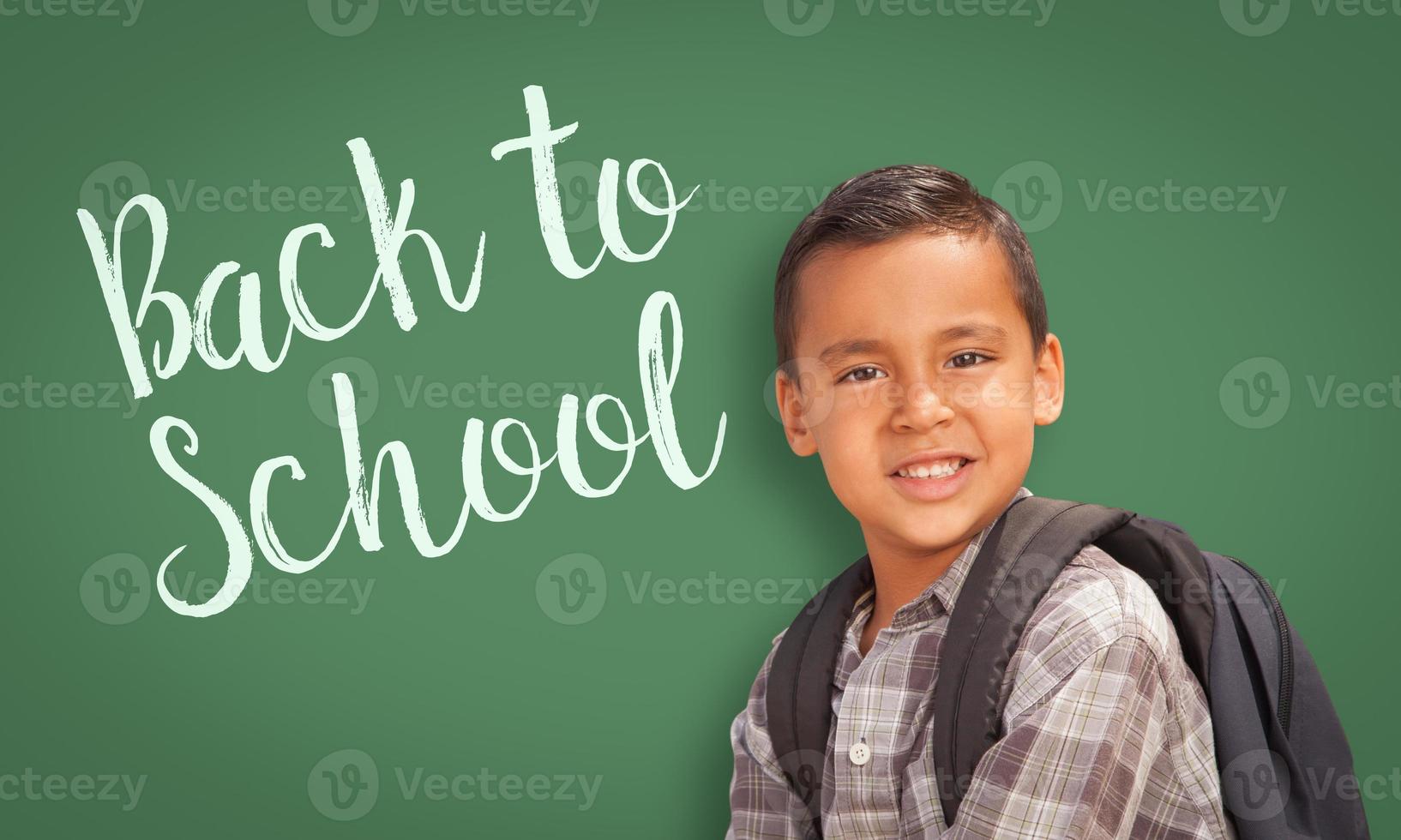 niño hispano frente a la pizarra de regreso a la escuela foto