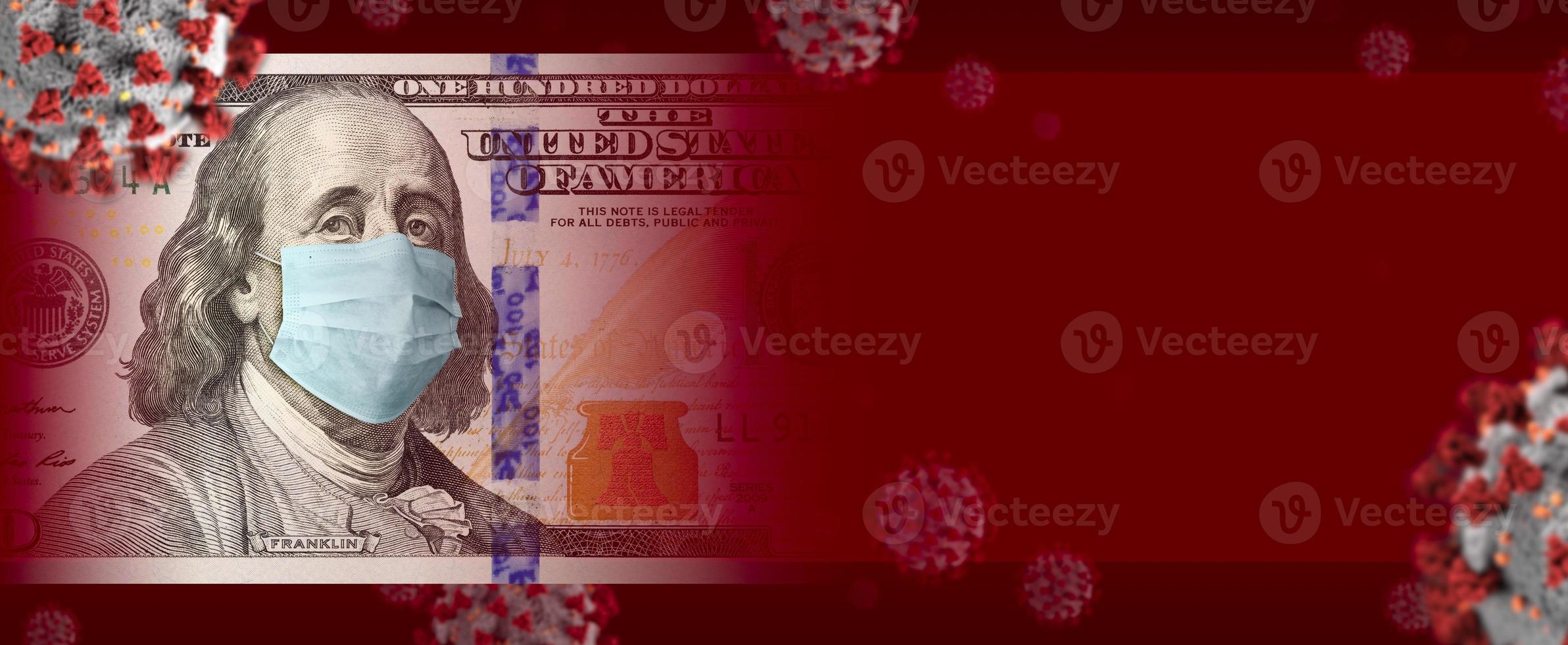 Billete de 100 dólares con mascarilla médica rodeada de pancarta de coronavirus foto