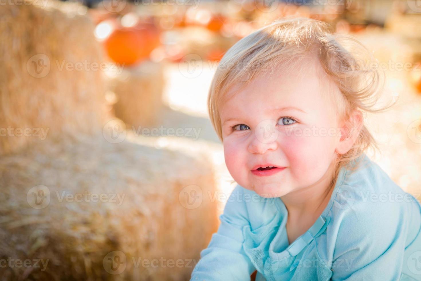 adorable niña divirtiéndose en un rancho rústico en el huerto de calabazas. foto