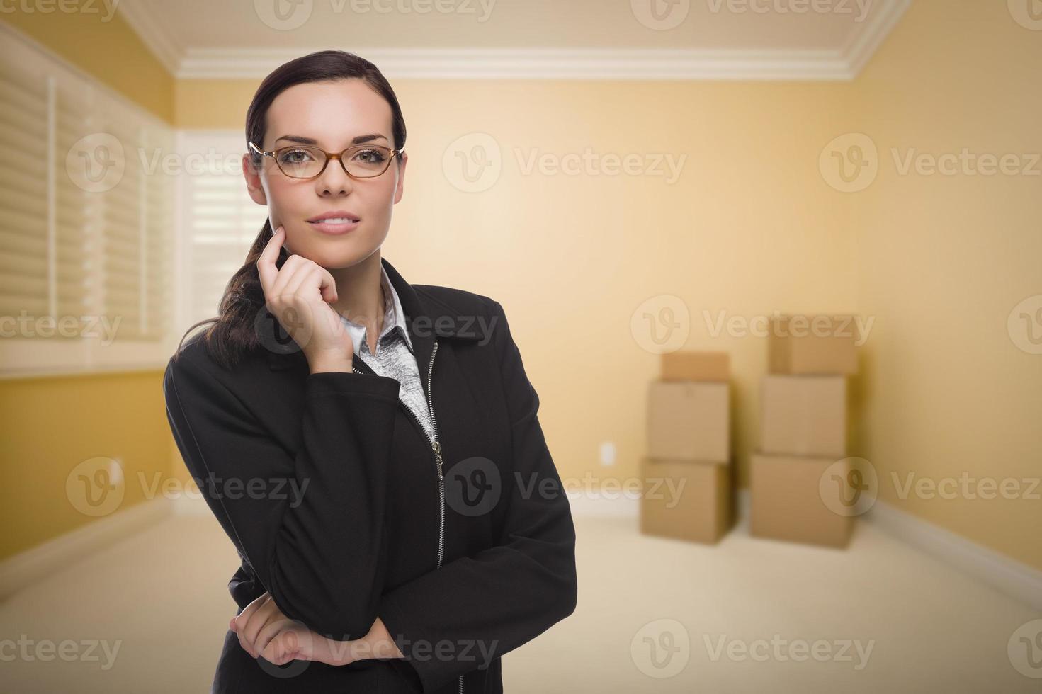mujer de raza mixta en una habitación vacía con cajas foto