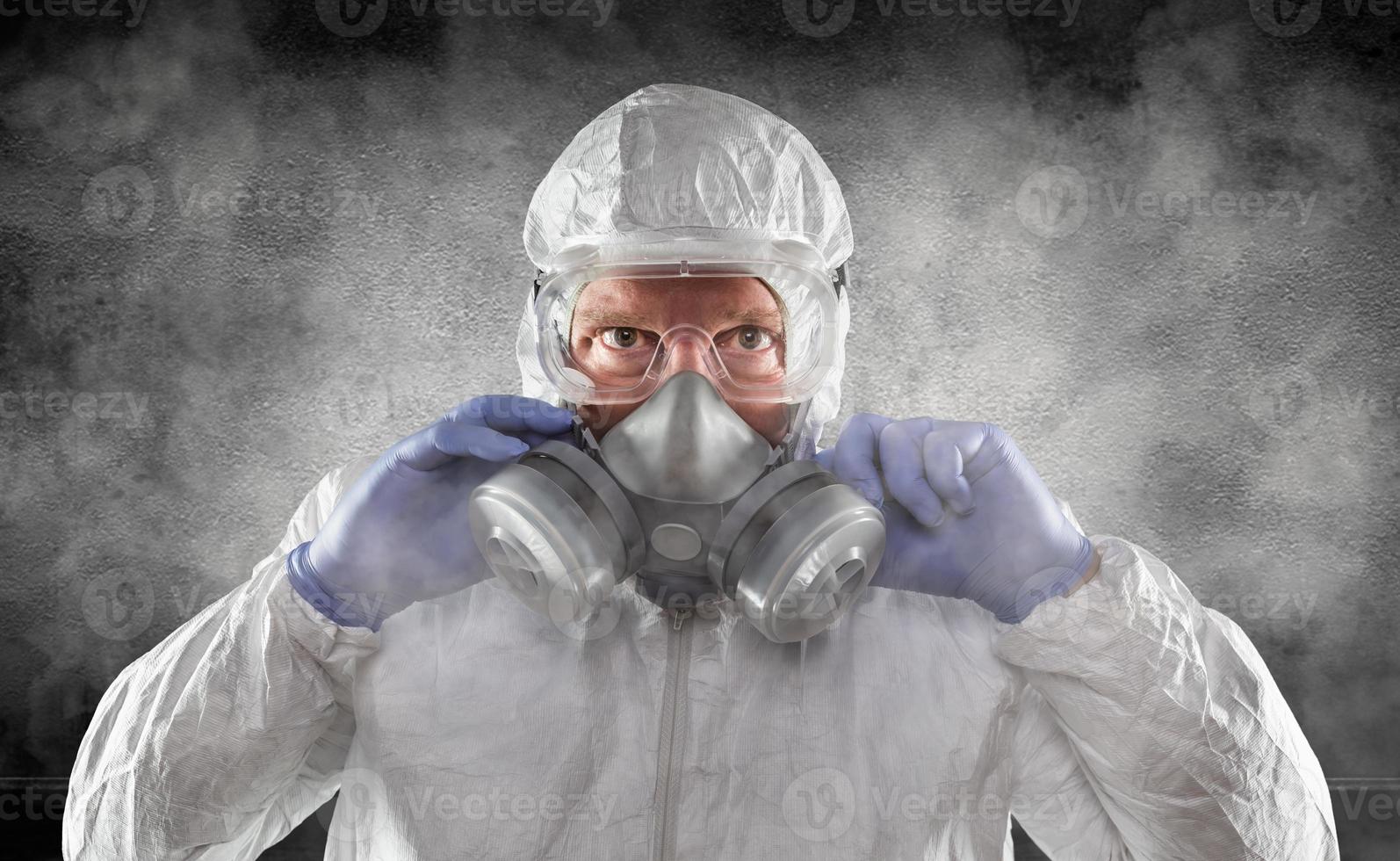 hombre con traje de materiales peligrosos, gafas y máscara de gas es una habitación oscura y ahumada foto