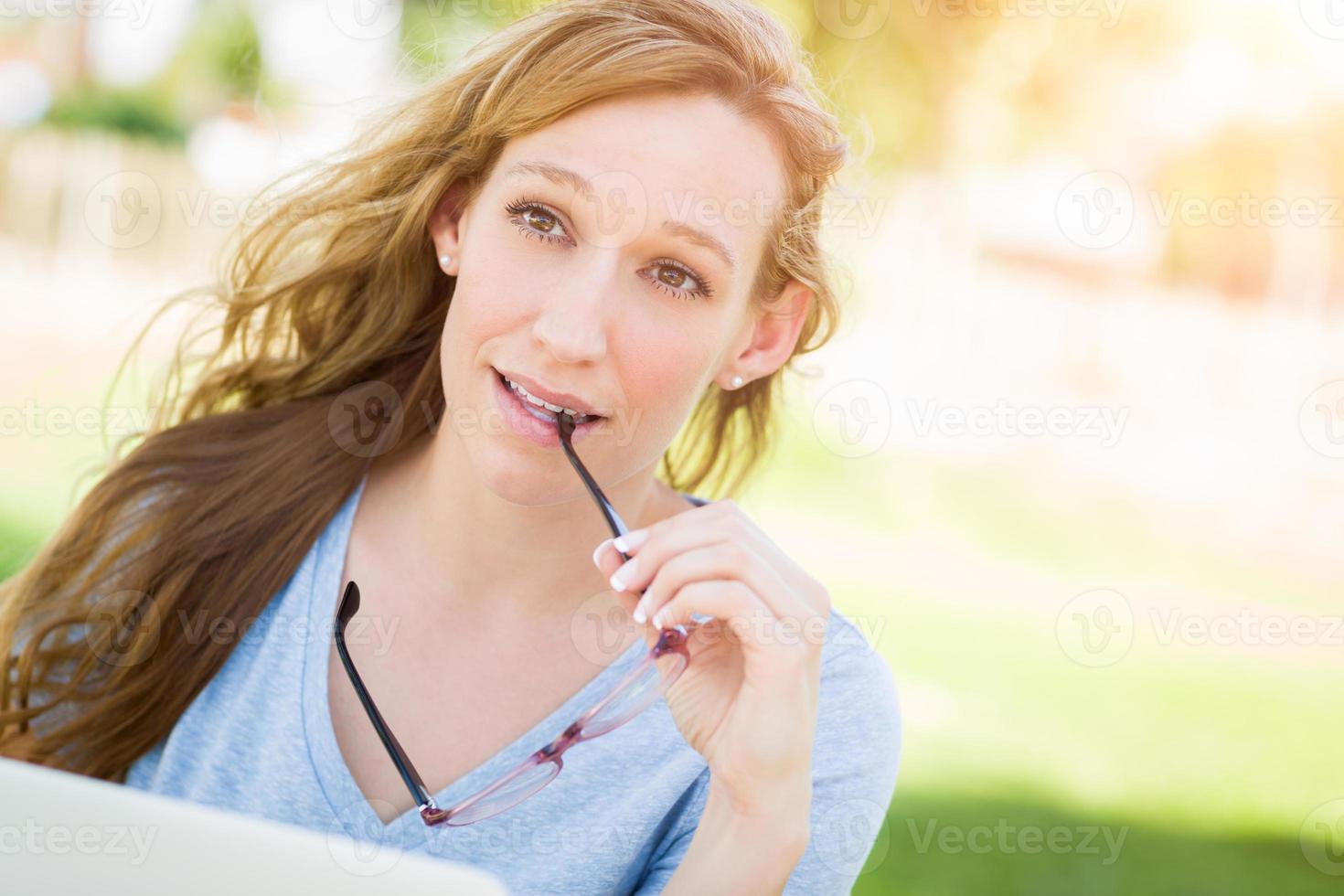 Young Adult Woman With Glasses Outdoors Using Her Laptop. photo