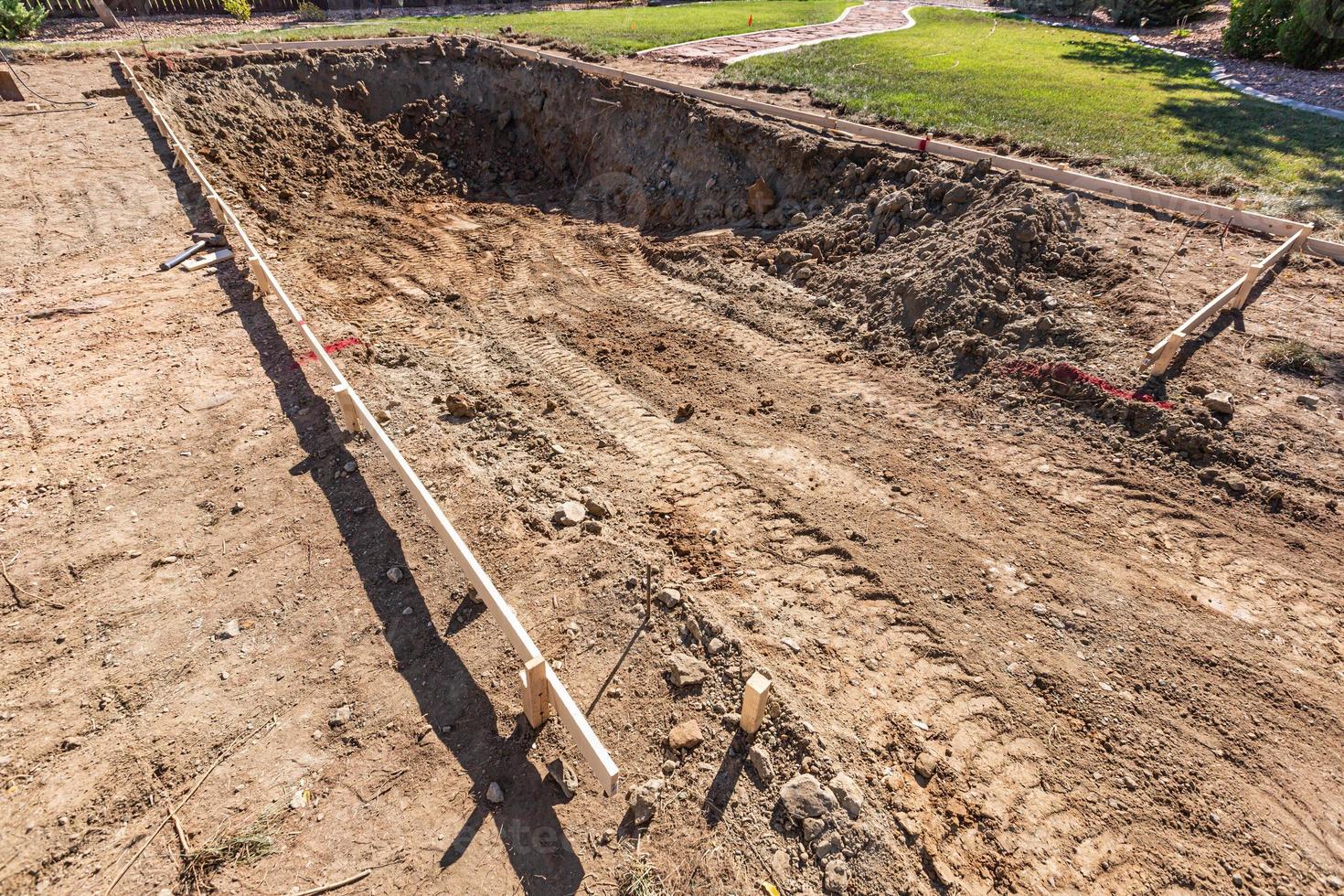 agujero recién excavado en el patio preparándose para la instalación de la piscina foto