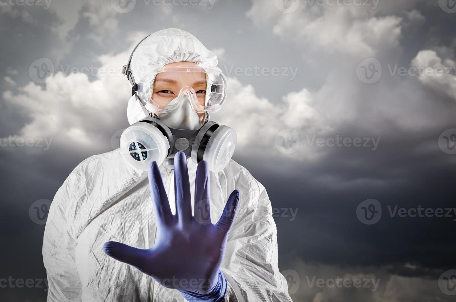 Chinese Woman Wearing Hazmat Suit, Protective Gas Mask and Goggles With Stormy Background photo