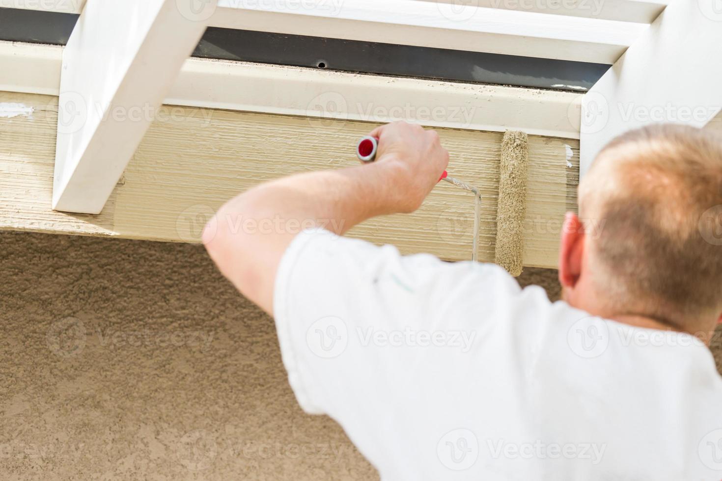 Professional Painter Using Small Roller to Paint House Fascia photo