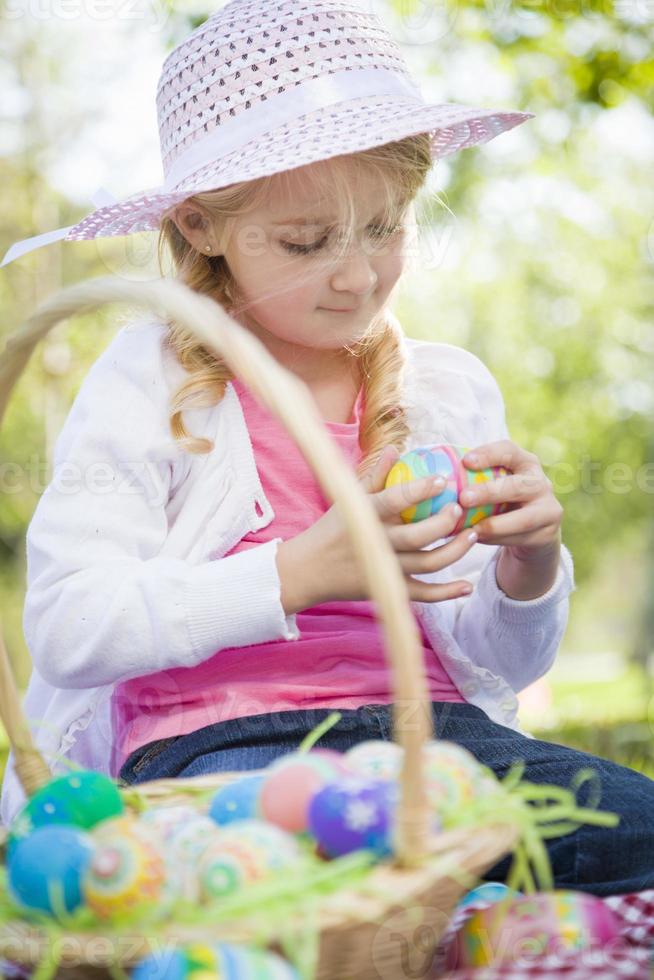 Cute Young Girl Wearing Hat Enjoys Her Easter Eggs photo
