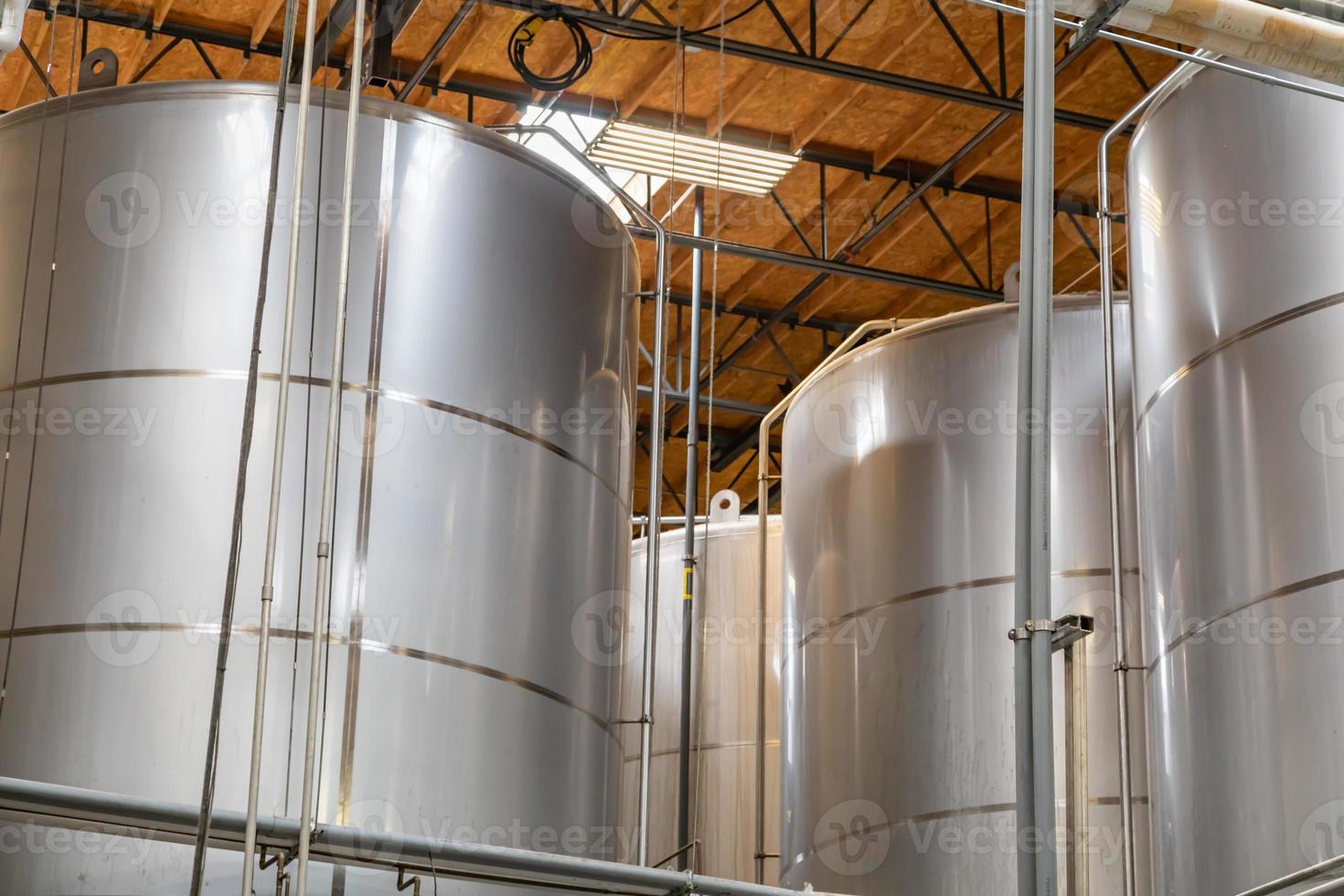 grandes tanques de fermentación de cervecería en almacén foto