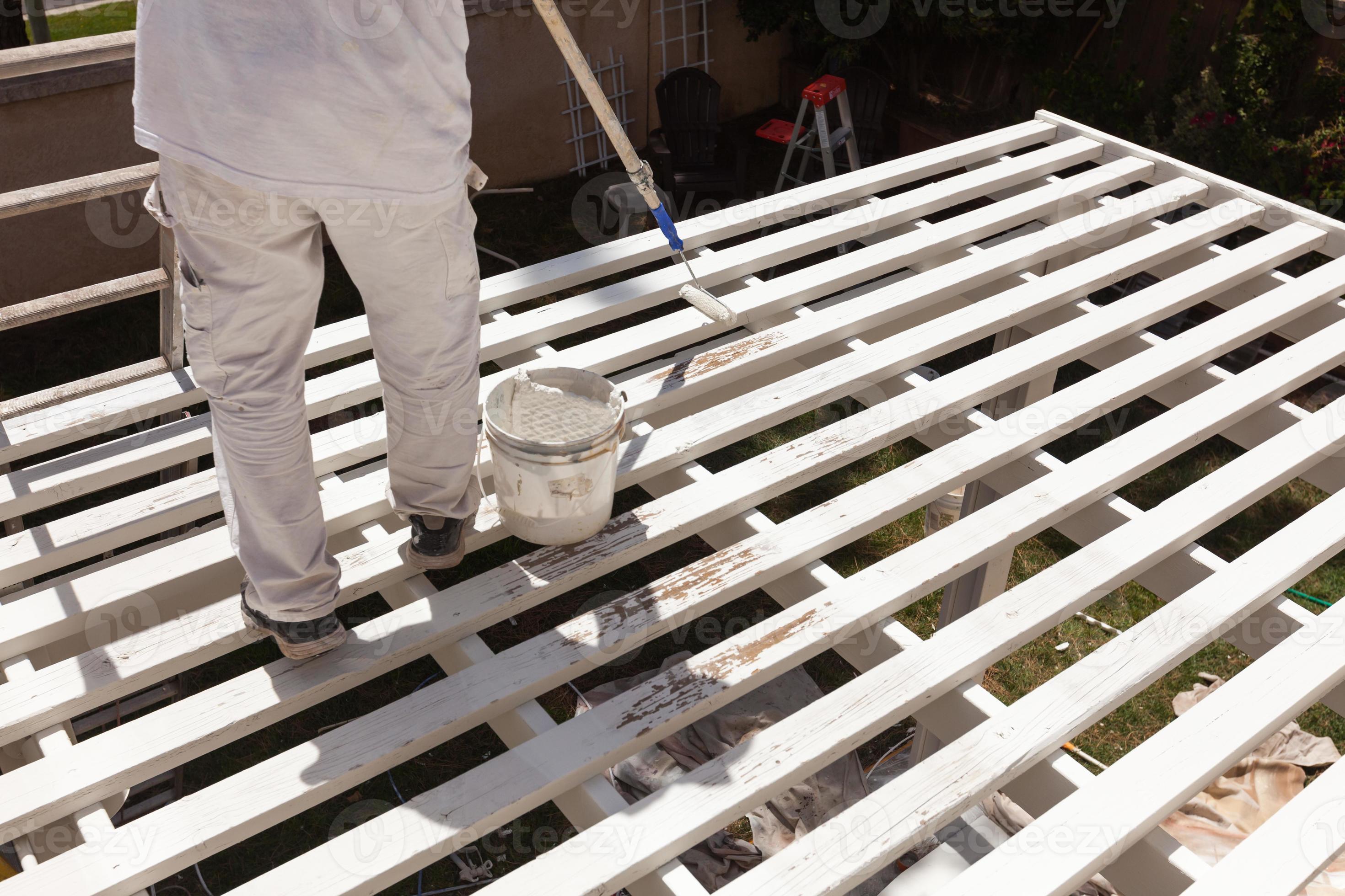 Professional Painter Rolling White Paint Onto The Top of A Home Patio