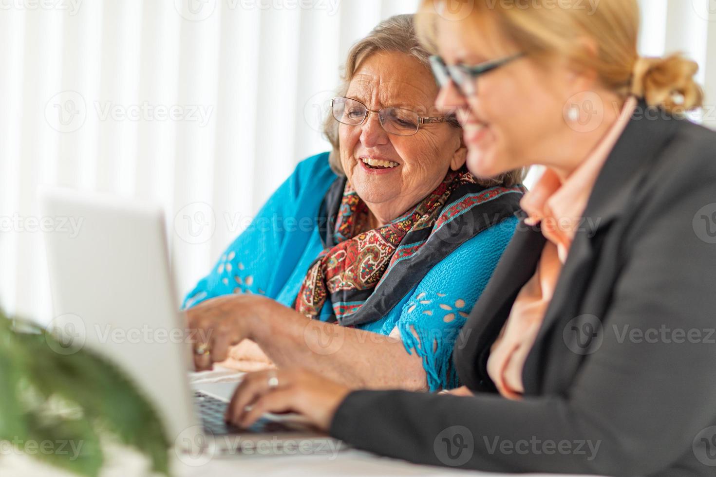 Woman Helping Senior Adult Lady on Laptop Computer photo