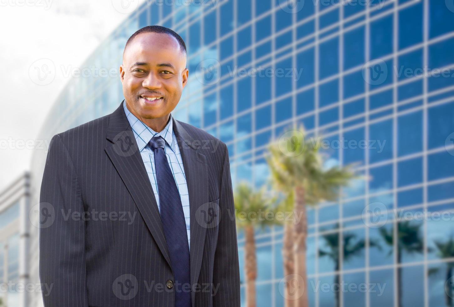 apuesto hombre de negocios afroamericano frente al edificio corporativo. foto