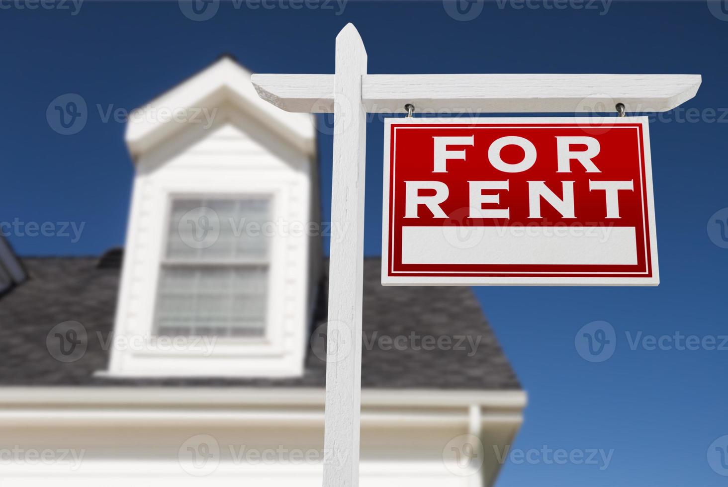 Right Facing For Rent Real Estate Sign In Front of House and Deep Blue Sky. photo