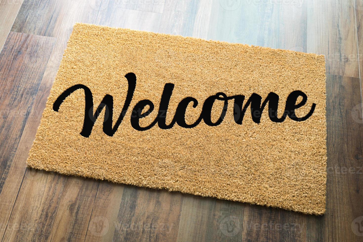 Tan Welcome Mat On Wood Floor Background. photo