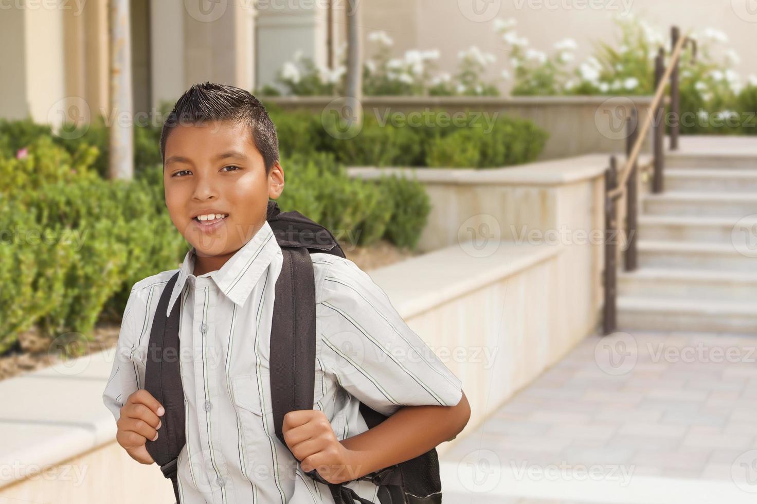 Happy Hispanic Boy with Backpack Walking on School Campus photo