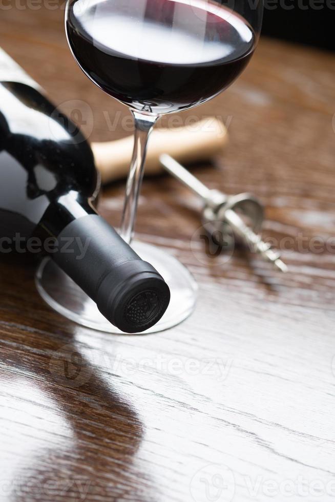 Abstract Wine Bottle, Glass and Corkscrew Laying on a Reflective Wood Surface. photo