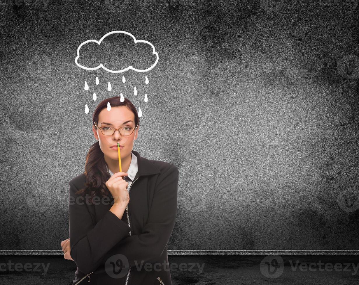 Rain and Cloud Drawn Above Head of Young Adult Woman With Pencil In Front of Wall with Copy Space photo