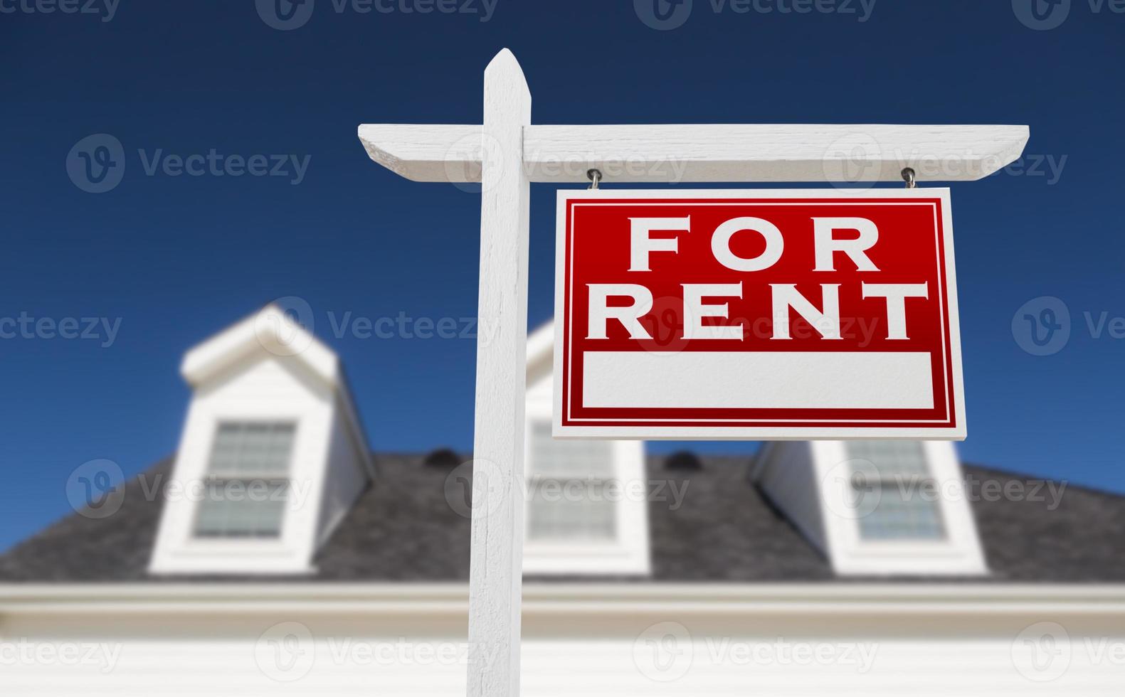 Right Facing For Rent Real Estate Sign In Front of House and Deep Blue Sky. photo